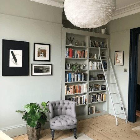 Living-room-with-light-green-walls-and-floor-to-ceiling-book-shelves