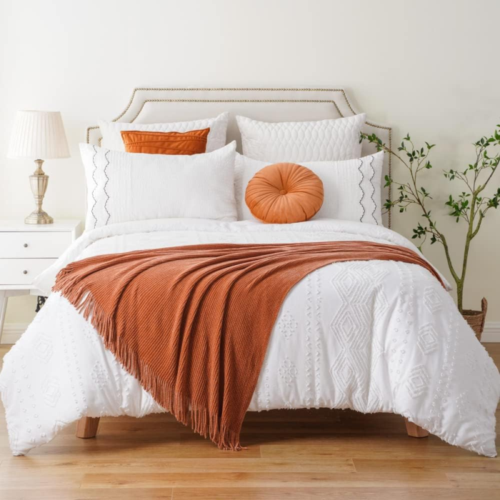 Cozy-bedroom-with-fall-color-palette-orange-pillows-throw-blankets