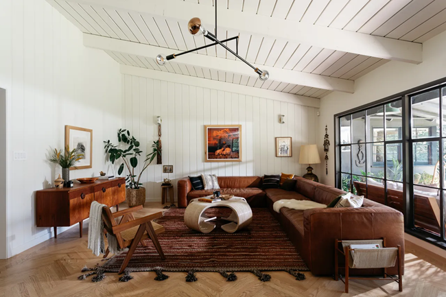 earthy-living-room-with-brown-leather-sectional-with-greenery-and-earthy-touches