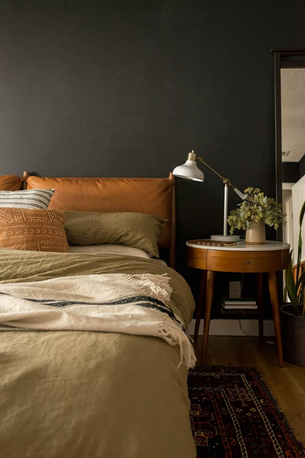 feminine-dark-bedroom-with-leather-headboad-and-cream-bedding